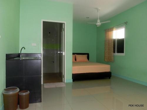 um quarto com uma cama e um lavatório em Pek House em Cidade Phuket