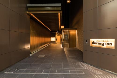 a long hallway with a sign on the side of a building at Dormy Inn Matsuyama Natural Hot Spring in Matsuyama