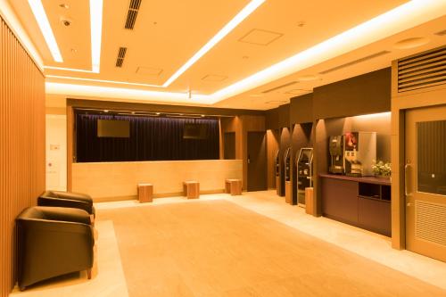 a conference room with chairs and refrigerators in it at Dormy Inn Matsuyama Natural Hot Spring in Matsuyama