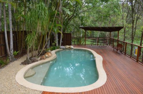 a swimming pool on a wooden deck with a wooden deck at Kondalilla Eco Resort in Montville