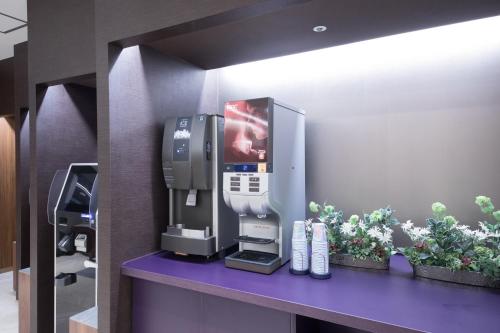 a coffee machine on a purple counter in a room at Dormy Inn Matsuyama Natural Hot Spring in Matsuyama