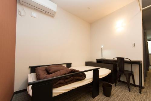 a bedroom with a bed and a desk and a table at Ryoma Ikebukuro in Tokyo