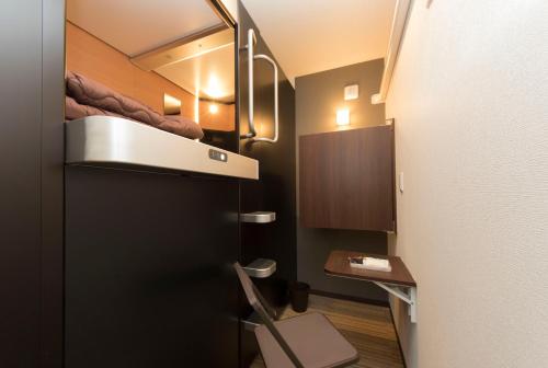 a small room with a bed and a toilet at Ryoma Ikebukuro in Tokyo