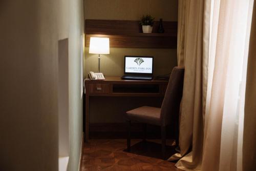 a desk with a laptop computer on top of it at Garden Park Inn in Almaty