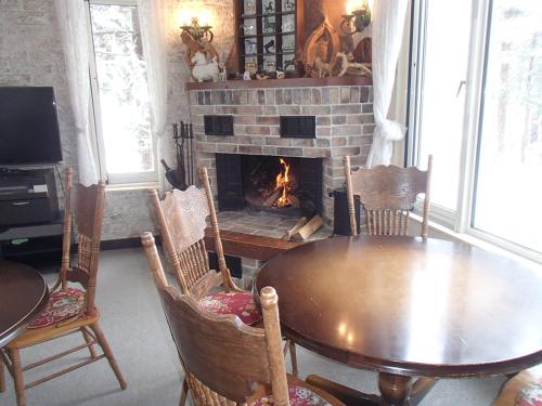 a dining room with a table and a fireplace at Rosenheim Hakuba in Hakuba
