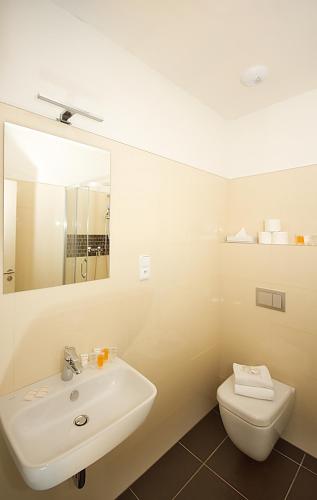 a white bathroom with a sink and a toilet at Elizabeth Suites in Prague