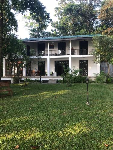 a white building with a yard in front of it at Villa by the Lake Bolgoda, Moratuwa-Colombo in Moratuwa