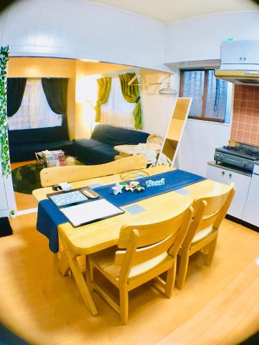 a table and chairs in a room with a kitchen at Holiday Homes TSUBOYA 301 in Naha