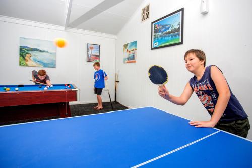 two boys playing a game of ping pong at BIG4 Shepparton Park Lane Holiday Park in Shepparton