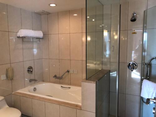 a bathroom with a bath tub and a shower at Xijiao Hotel Beijing in Beijing