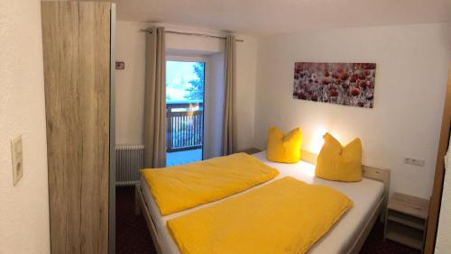 a bedroom with two beds with yellow pillows at Appartements Dobler - s'Darhuam in Sankt Leonhard im Pitztal