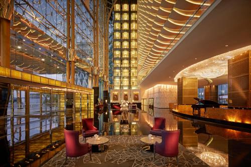 - un hall avec un piano à queue, des tables et des chaises dans l'établissement The Meydan Hotel Dubai, à Dubaï