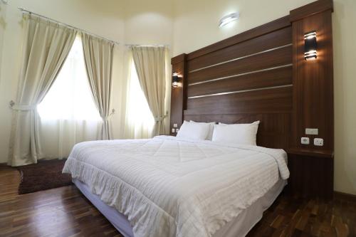 a bedroom with a large bed with a wooden headboard at Diyar Villas Puncak NB3/3 in Puncak