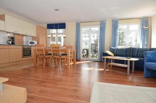 a kitchen and living room with a table and chairs at Villa Seerose - Appartement 09 in Ostseebad Sellin