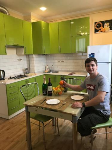 a man sitting at a table in a kitchen at VIP Apartament in the center in Truskavets