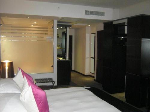a bedroom with a large bed with a pink pillow at Coastlands Umhlanga Hotel and Convention Centre in Durban
