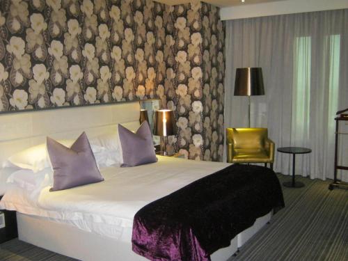a bedroom with a large bed with purple pillows at Coastlands Umhlanga Hotel and Convention Centre in Durban