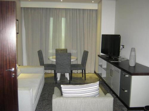 a living room with a couch and a tv in a room at Coastlands Umhlanga Hotel and Convention Centre in Durban