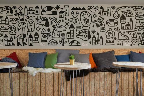 a couch with two tables in front of a wall at Haystack Hostel in Edinburgh