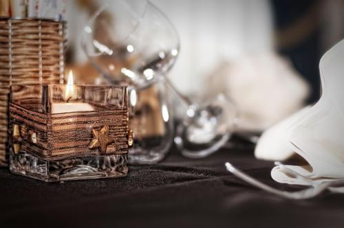 a candle in a glass container on a table at Hotel Everest in Trento