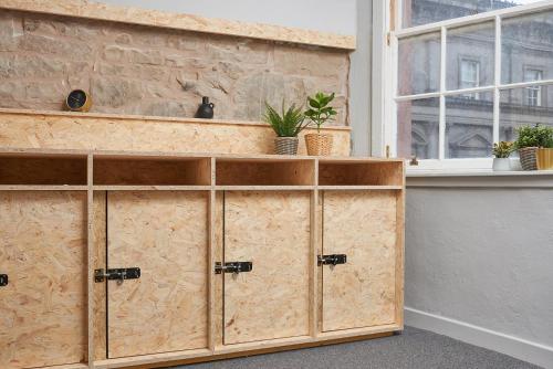 a set of wooden cabinets in a room with a window at Haystack Hostel in Edinburgh