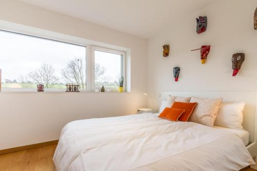 a bedroom with a white bed and a large window at stylish flat lux-city in Luxembourg