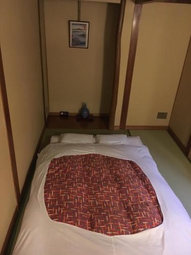 Una cama en una habitación con una alfombra. en Hotel Edoya en Tokio