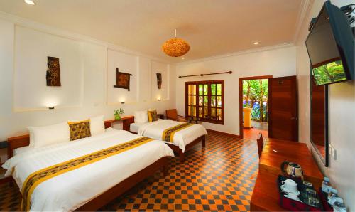 A bed or beds in a room at Le Jardin d'Angkor Hotel & Resort