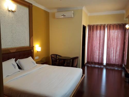 Säng eller sängar i ett rum på Akshaya Palace Inn