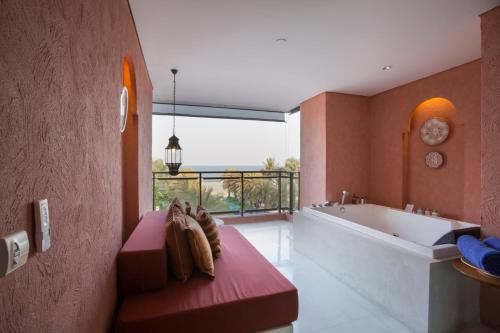 a bathroom with a bath tub and a large window at Marrakesh Hua Hin Resort & Spa in Hua Hin