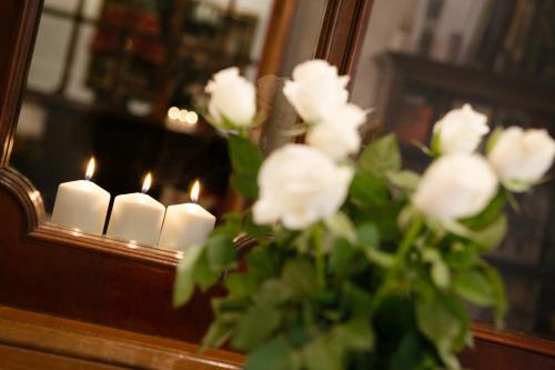 a vase with white flowers in front of a mirror at Domus Socolatae Residenza d'Epoca Charming B&B - Adults Only in Follonica