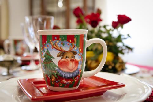 a coffee cup with a reindeer on it on a table at Domus Socolatae Residenza d'Epoca Charming B&B - Adults Only in Follonica