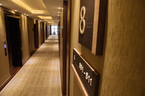 an empty hallway in a hotel with a sign on a wall at Garden Park Inn in Almaty