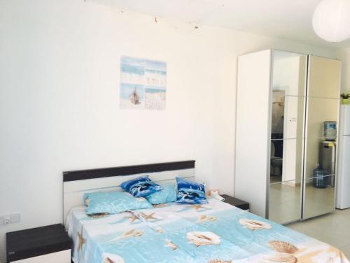 a bedroom with a large bed with blue pillows at Apartment Caesar Beach in Kalecik