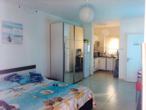 a bedroom with a large bed and a kitchen at Apartment Caesar Beach in Kalecik