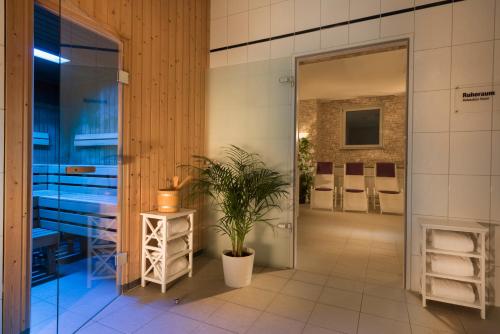 a bathroom with sinks and a potted plant at AHORN Hotel Am Fichtelberg in Kurort Oberwiesenthal