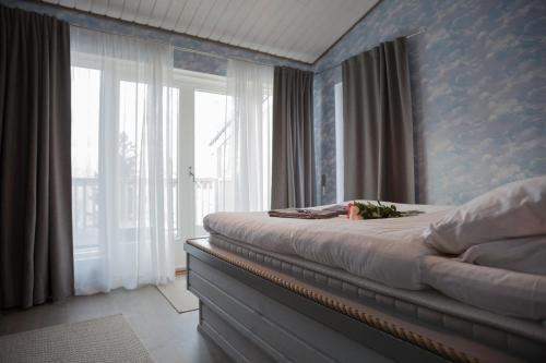 a bedroom with a bed and a large window at Villa Seaview Guesthouse & Spa in Teijo