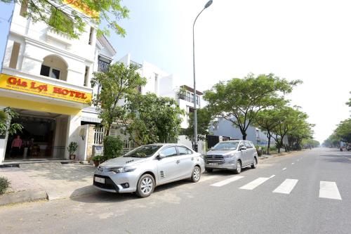 two silver cars parked on the side of a street at Gia Loi Hotel in Da Nang