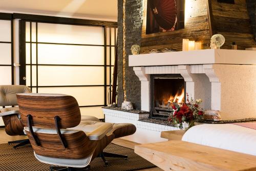 a bedroom with a fireplace and a chair and a bed at Snow Lodge Hotel Courchevel 1850 in Courchevel