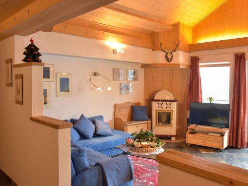 a living room with a blue couch and a tv at Residence Salvan in Corvara in Badia