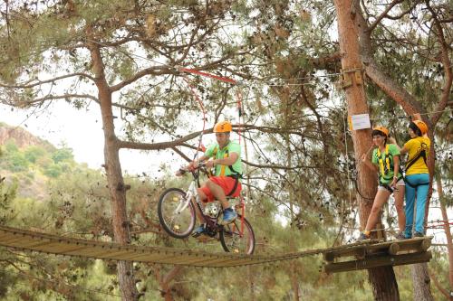 a man riding a bike on a suspension bridge at Utopia World in Mahmutlar
