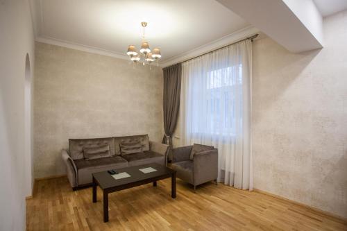 een woonkamer met een bank en een tafel bij Mickeviciaus str apartment in Kaunas