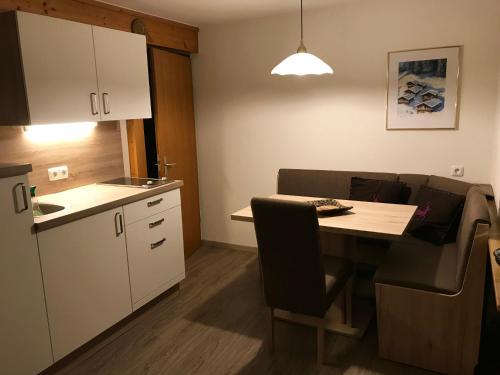 a small kitchen with a table and a dining room at Gästehaus Schneeberger in Matrei in Osttirol
