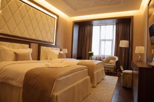 a hotel room with two beds and a window at Garden Park Inn in Almaty