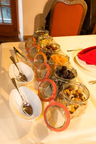 a table with spoons and bowls of food on it at Hostellerie Les Bagenelles in Sainte-Marie-aux-Mines