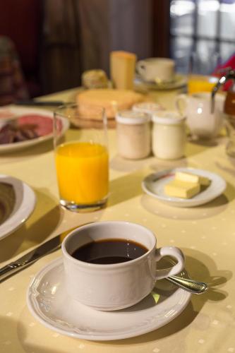 a cup of coffee on a white plate on a table at Hostellerie Les Bagenelles in Sainte-Marie-aux-Mines