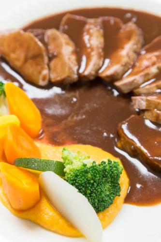 a plate of food with meat and broccoli and sauce at Hostellerie Les Bagenelles in Sainte-Marie-aux-Mines
