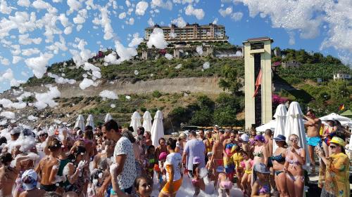 a crowd of people on a beach with a castle at Utopia World in Mahmutlar