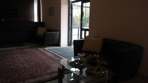a living room with a couch and a glass table at Hotel Julian&oacute;w in Warsaw
