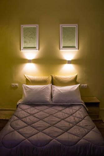 a bedroom with a bed with two lights above it at Bonne Nuit Pension in Nafplio